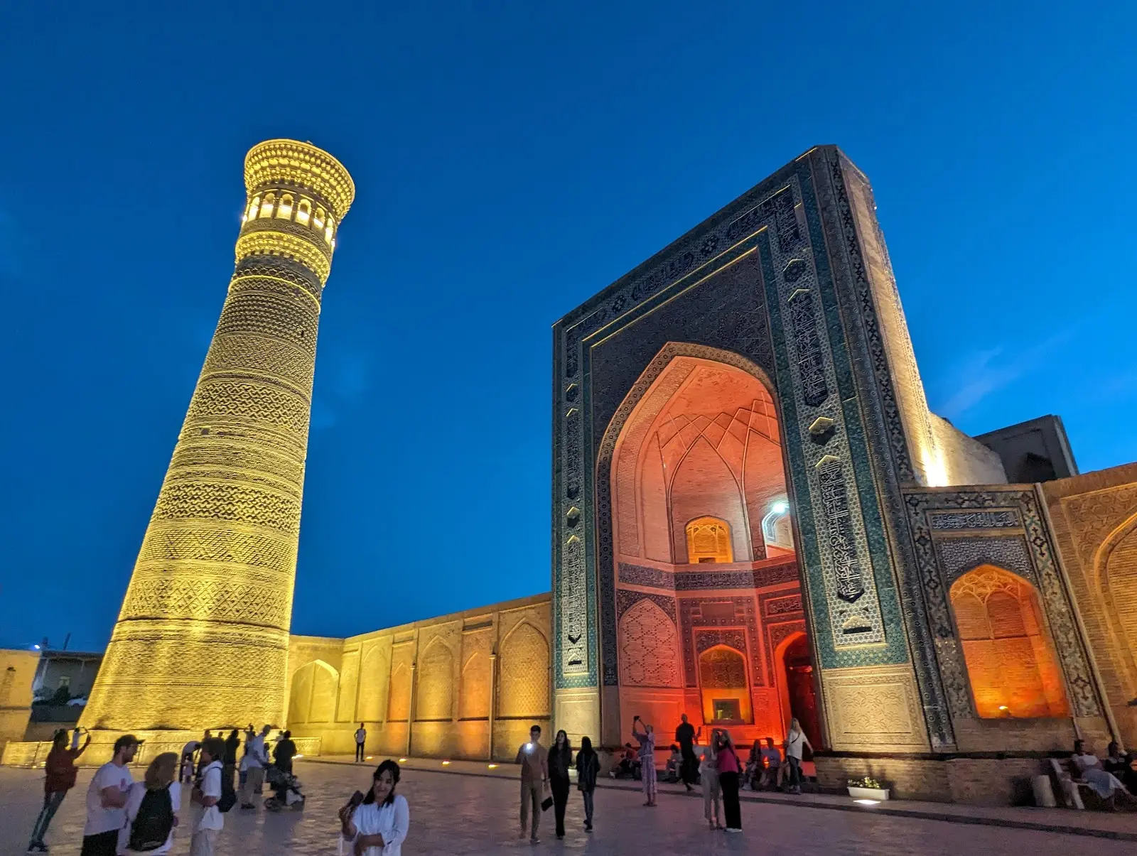 The iconic brick Kalyan Minaret and azure domes of Mir-i-Arab Madrasa in Bukhara